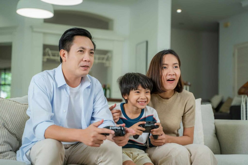 Family sitting on the couch together playing video games.